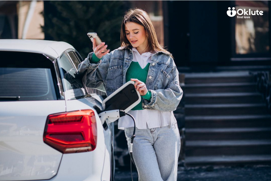 Electric Vehicles vs. Hybrid Vehicles: Which Is Better for Your Driving Needs? Woman using her phone while charging an electric vehicle